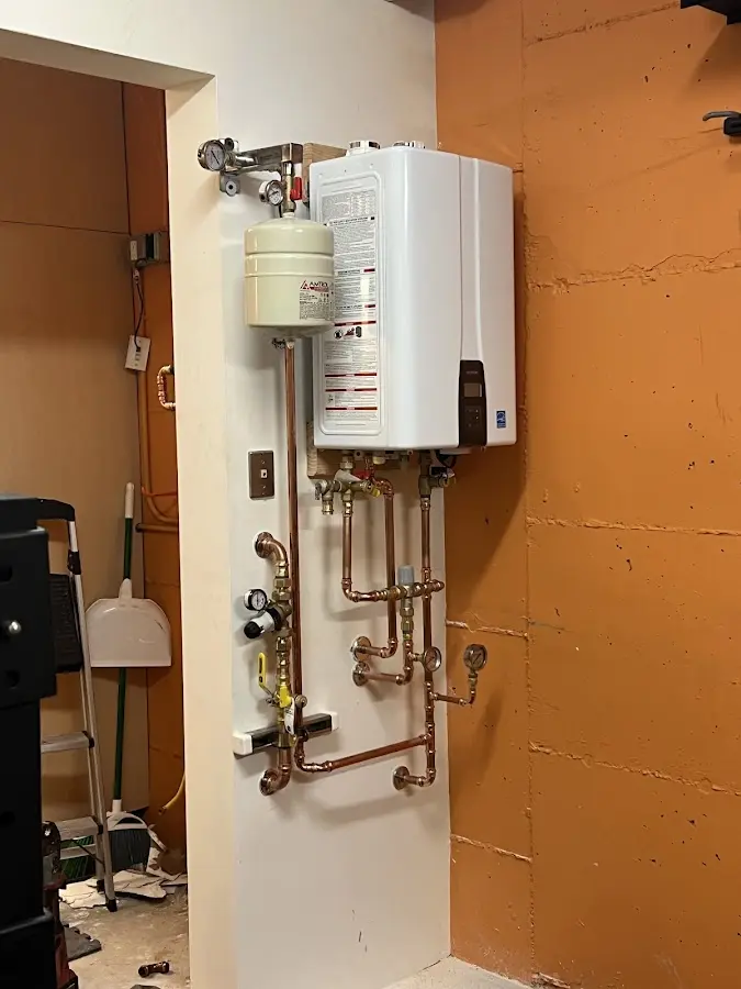Plumbing technician inspecting water heater connections in Winder